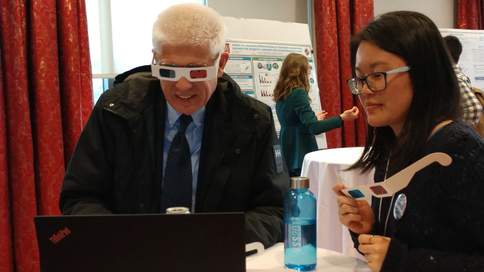 Dean O'Kelly views a students presentation at the Poster Session